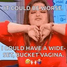 a woman in a red sweater is making a funny face with her hands around her face .