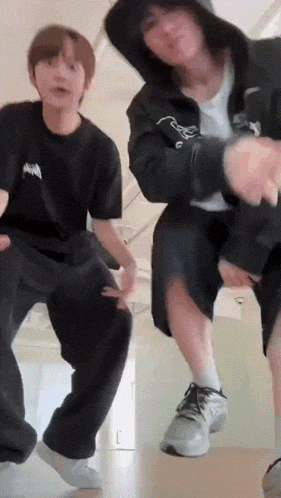 a couple of young men are dancing together on a staircase .