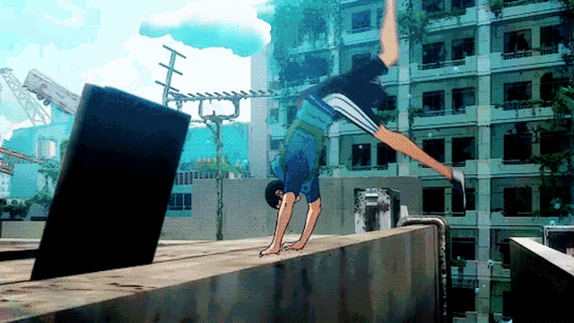 a man doing a handstand on a ledge in front of a building