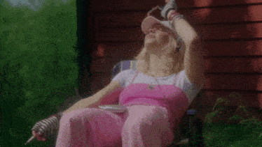 a woman wearing headphones and a visor sits in a chair outside