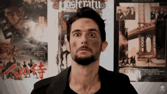 a man in front of a poster that says " nosferatu " on it