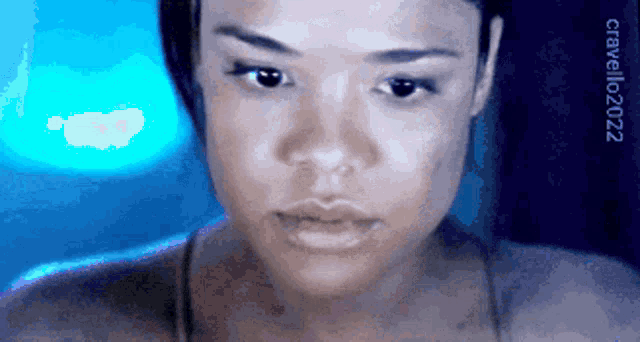 a close up of a woman 's face with a blue light behind her and a watermark that says cirquello2022