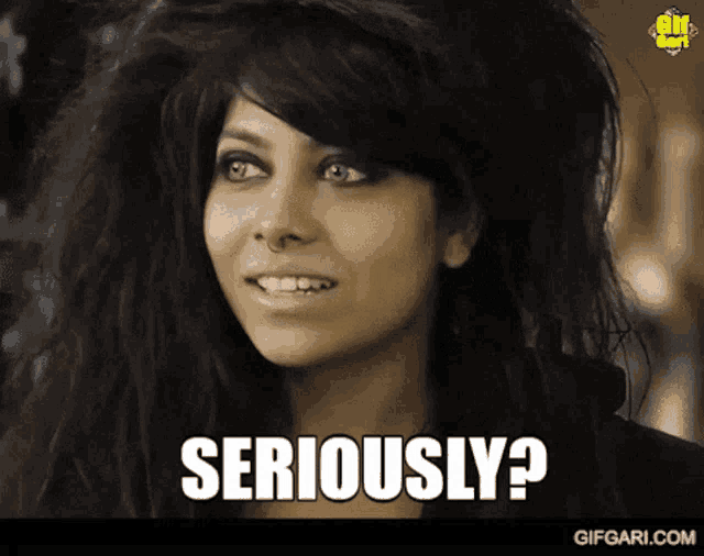 a woman with long black hair is smiling and says seriously ?