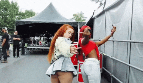 two women are standing next to each other and one is pointing