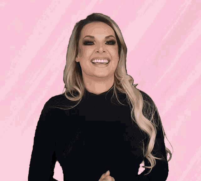 a woman in a black top is laughing with her mouth open