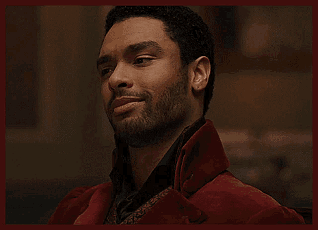 a man with a beard is wearing a red coat