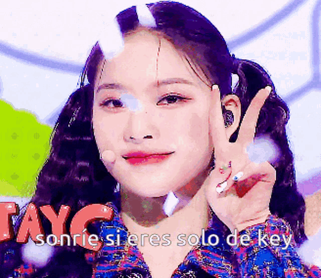 a woman giving a peace sign with the words sonrie si eres solo de key written below her