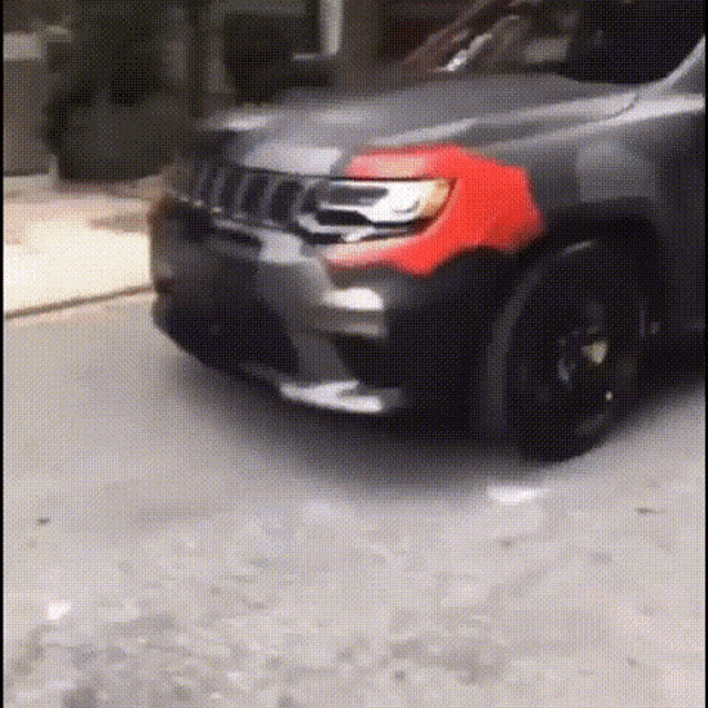 a jeep is parked on the side of the road with a red stripe on the front fender .