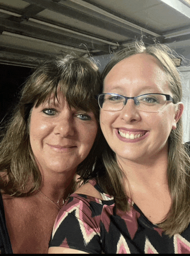 two women are posing for a picture and one has glasses