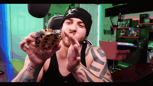 a man with a tattoo on his arm is holding a turtle and giving the middle finger