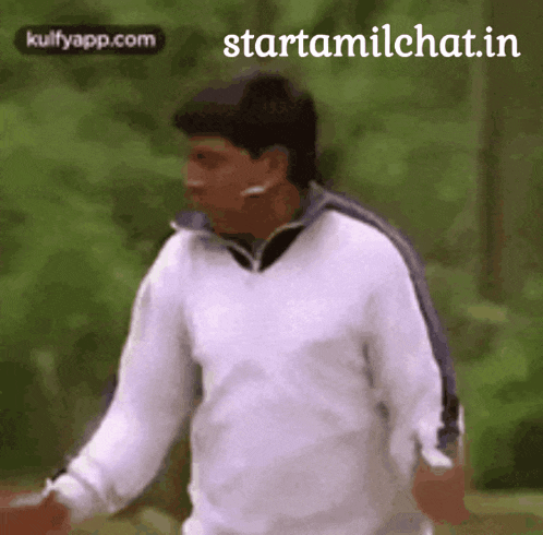 a man in a white sweater is walking in a park with the words starttamilchat.in on the bottom