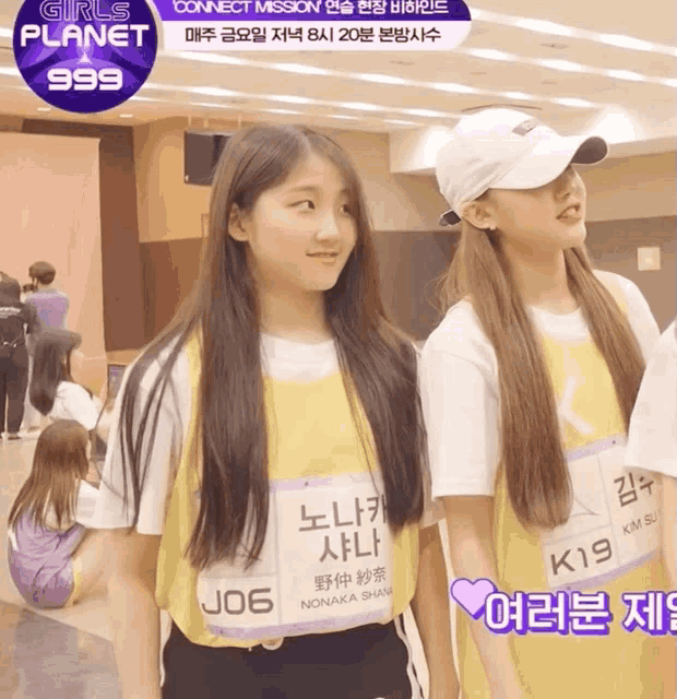 two girls are standing next to each other in front of a screen that says girls planet 999