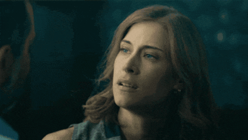 a woman with red hair is looking at a man