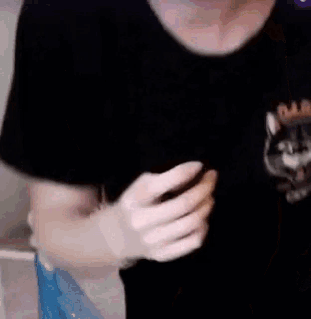 a close up of a person 's chest with their hands on it .