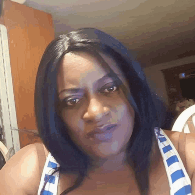 a woman wearing a blue and white striped shirt looks at the camera