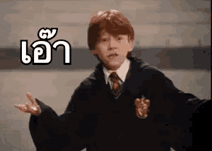 a young boy in a harry potter uniform is making a funny face and giving a peace sign .