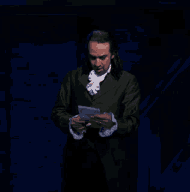 a man in a green suit is holding a piece of paper .