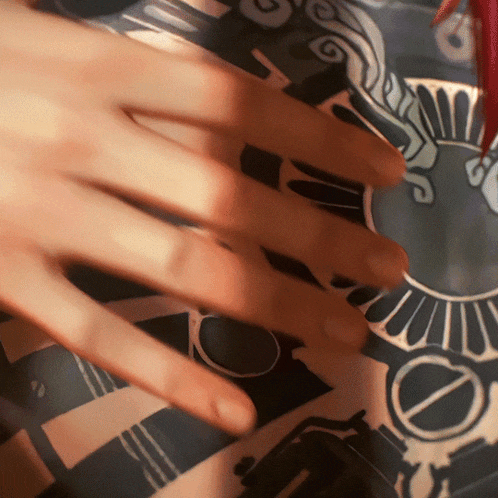 a close up of a person 's hand touching a patterned cloth