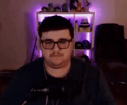 a man wearing glasses and headphones is standing in front of a microphone in a room .