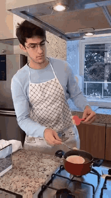 a man in an apron is cooking in a pot