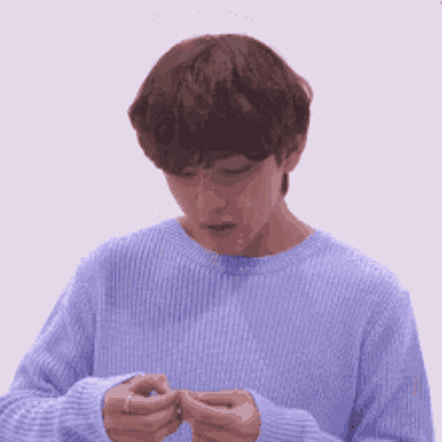 a man in a blue sweater is holding a ring in his hand .