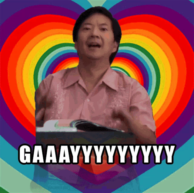 a man with a rainbow heart in the background says gaaayy
