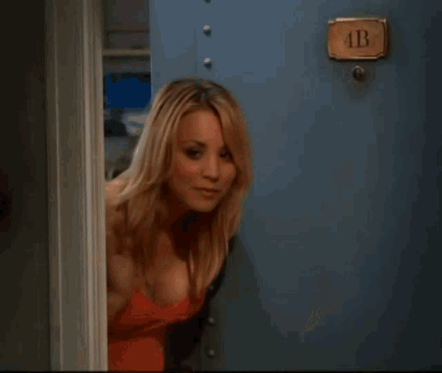 a woman in a red bra is standing in front of a door that has a sign that says r on it