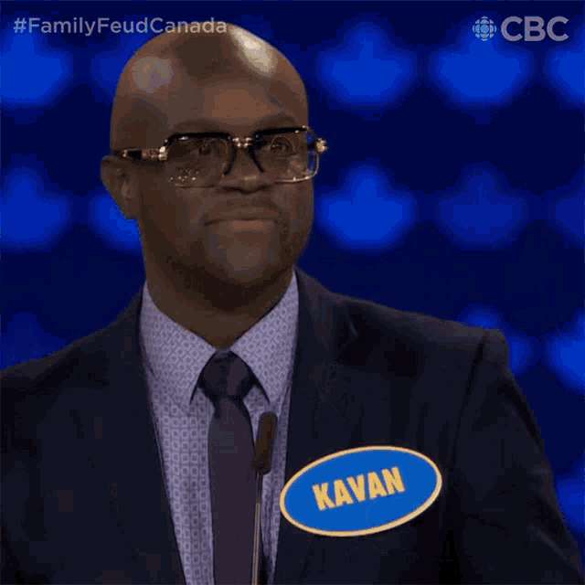 a man wearing a suit and tie has a name tag that says kavan