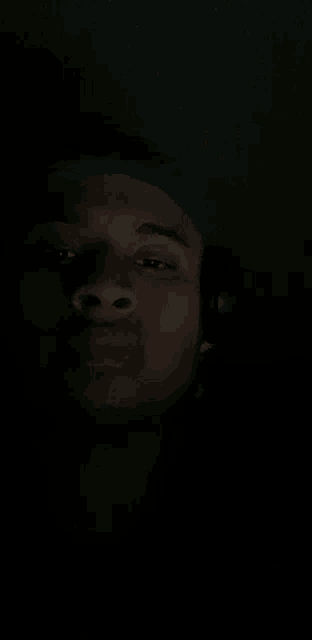 a man is wearing headphones in the dark .