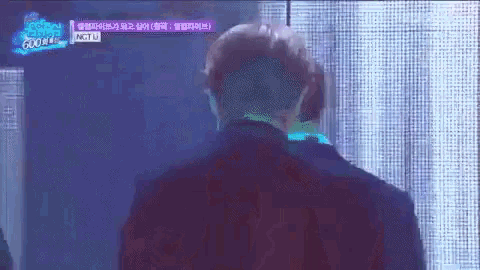 a man is standing in front of a screen that says nct u on it