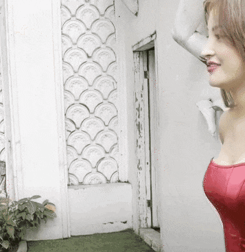 a woman in a red dress standing in front of a white wall