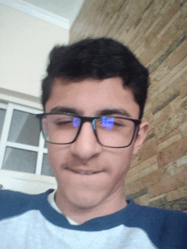 a young man wearing glasses has his eyes closed and his mouth open
