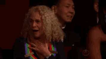 a woman wearing a rainbow colored ribbon around her neck