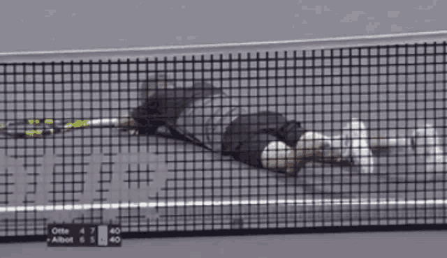 a tennis player is laying on the court with a racket in his hands