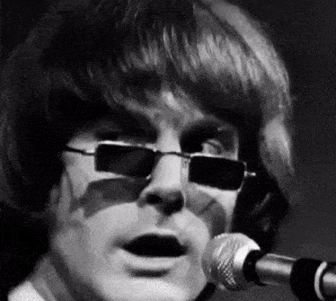 a man is singing into a microphone wearing sunglasses