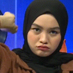 a woman in a hijab is making a funny face .
