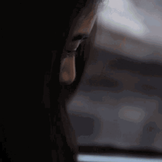 a close up of a woman 's face with a tear coming out of her eye