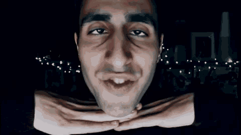 a close up of a man 's face with his hands on his chin