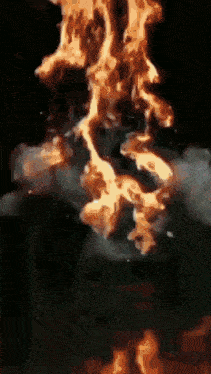 a close up of a fire with smoke coming out of it in a dark room