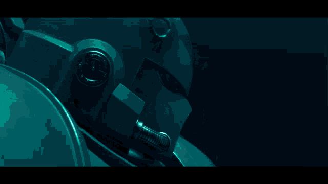 a close up of a robot 's head with a green glow