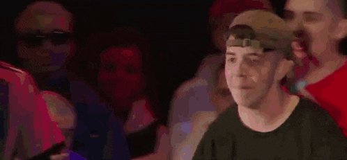 a group of young men are sitting in a stadium watching a game and one of them is screaming .