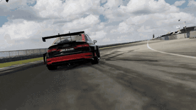 a red and black audi r8 lms is driving down a track