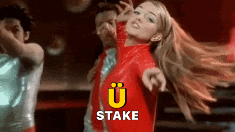 a woman in a red jacket is dancing in front of a sign that says ' stake '