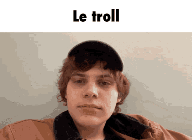 a man wearing a hat and a brown jacket with the words le troll written above him