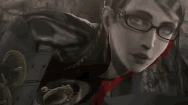 a woman wearing glasses and a black jacket has a red ribbon around her neck