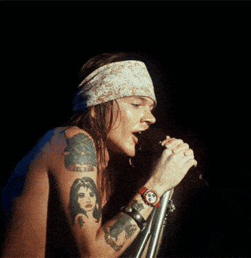 a man singing into a microphone with a watch on his wrist
