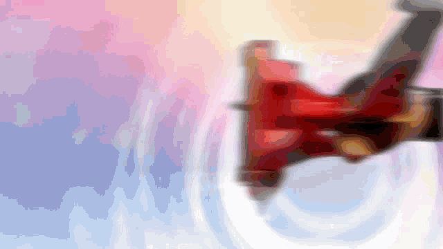 a blurry picture of a person holding a red object with a pink and blue background