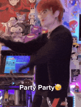 a man with red hair and glasses is dancing in front of a video game machine with the words party party written on it