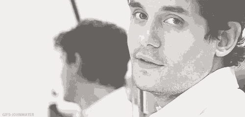 a man is looking at his reflection in a mirror .