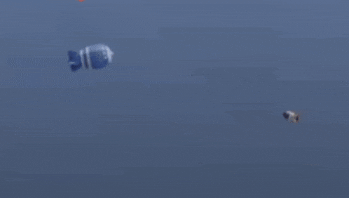 a white circle is floating in the middle of a blue ocean .